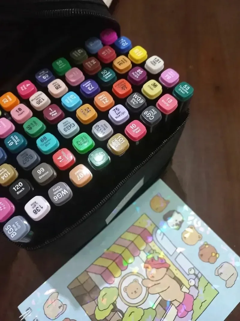 Foto das tampas coloridas e numeradas das canetinhas dentro do estojo