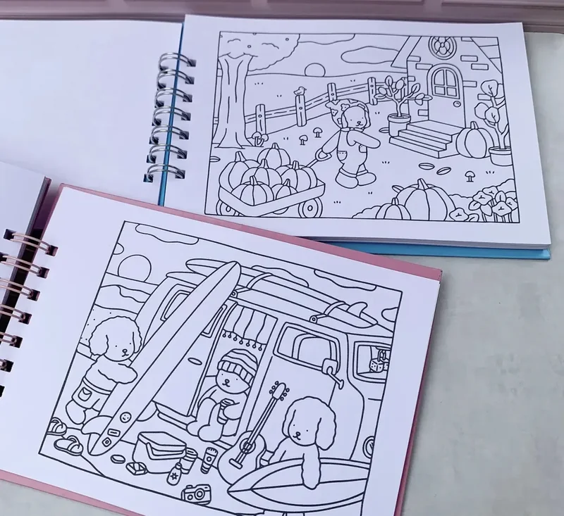 Fotografia de dois livros abertos com ilustrações de animais para colorir